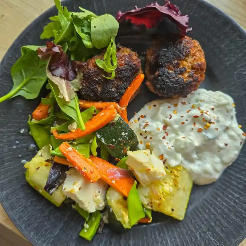 Billig hemlagad måltid: Tallrik med köttbullar och grönsaker, ett smart sätt att spara pengar på mat genom storkok